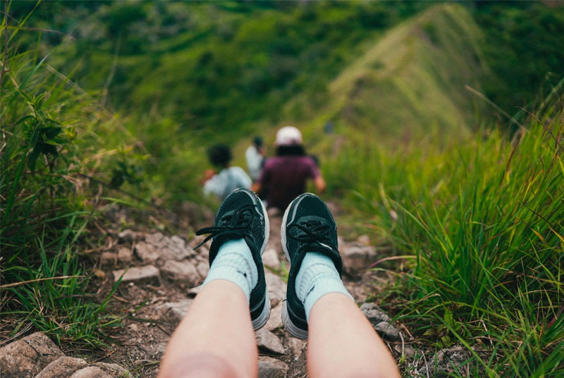 POV of durable Merino wool hiking socks on a rugged trail.