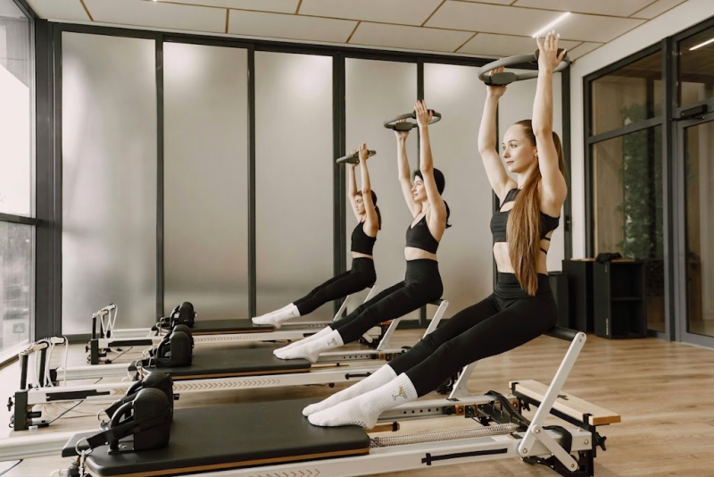 People wearing Pilates socks while exercising on a reformer